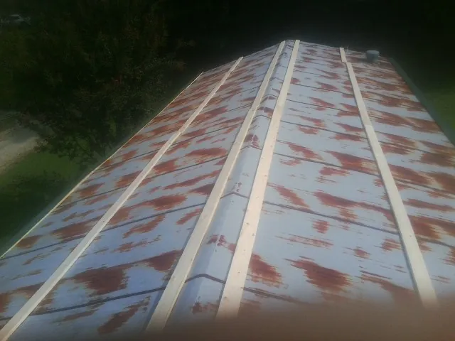 Rusted metal roof panels with new wood purlins before replacement — Storm Damage Roof Repair in Kennedy by Roofing Brothers