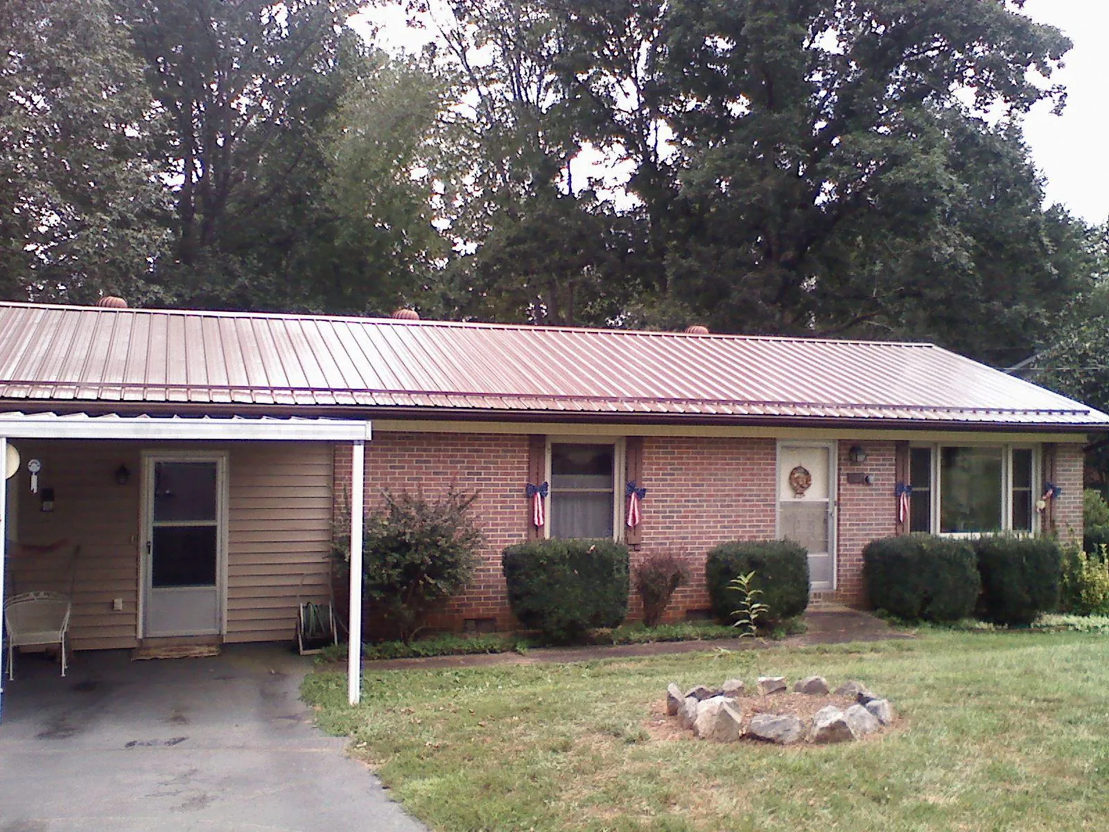 Bronze metal roof and carport on a brick ranch home — Roof Repair work by our crew in Kennedy